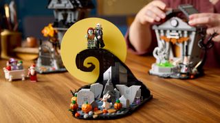 Lego The Nightmare Before Christmas graveyard hill and minifigures laid out on a wooden table